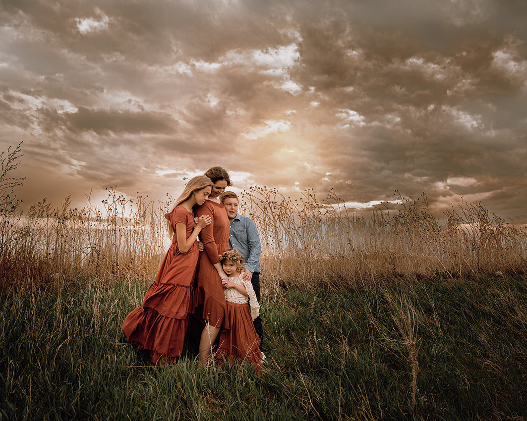Mother with children in a grassy field during a motherhood family photography session near Sioux Falls, South Dakota.